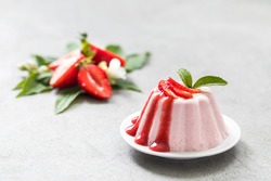 Dessert, creamy strawberry pudding with sauce on a plate on a light background