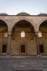 Courtyard of Bayezid Mosque in Fatih, İstanbul. Arched structure of the mosque. Stone vaulted courtyard. Religious building consisting of domes and columns. Light to prayer.