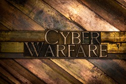Photo of real authentic typeset letters forming Cyber Warfare text on vintage textured grunge copper background