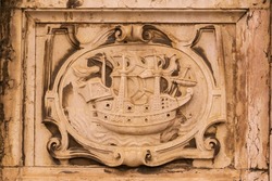 Stone heraldic coat of arms with ship on the wall