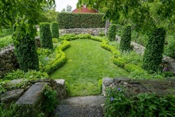 Sunken Garden at Weir Farm National Historic Site. Designed by Cora Weir. Colonial Revival style, small intimate space, defined by stone walls, curved beds, tall arborvitae and dwarf boxwood. 
