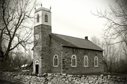 Old style photograph of an old, small, early 19th century, stone church in the country.