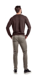 A back view on a modern fit and casually clothed man that stands in a relaxed posture and looks sideways. Man from back. Modern garb. Unrecognizable person.