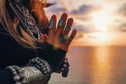 close up of woman hands. tribal style woman on the beach at sunset