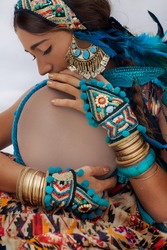 attractive young woman in ethnic jewelry with drum. close up portrait. 