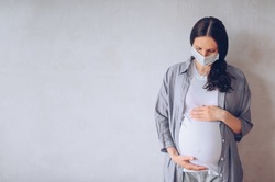 Sad pregnant woman wearing medical face masks due to illness, dizziness against infectious diseases and flu. Healthy pregnancy concept. Pregnancy And Infection. Copy space mock up. White background