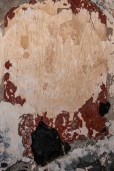 Old plastered volcanic rock stonework wall with worn out red peeling paint, grunge background