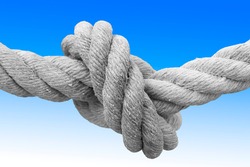 Strong rope with single knot - concept image against a blue and white background.