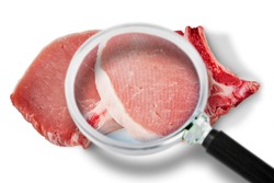 Fresh pork steak HACCP (Hazard Analyses and Critical Control Points) concept with image seen through a magnifying glass - Food Safety and Quality Control in food industry.