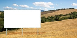Blank advertising signboard in a italian rural scene with hills and cut wheat field - concept  with copy space for inserting text