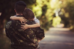 Woman and soldier in a military uniform say goodbye before a separation