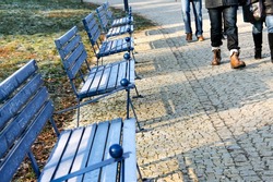 blue benches lined up and people's legs in winter