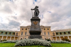 Monument against the backdrop of the palace and the cloudy sky. Translation: Emperor Paul I, founder of Pavlovsk