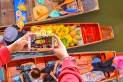 Smartphone photographing Damnoen Saduak floating market in Ratchaburi near Bangkok, Thailand