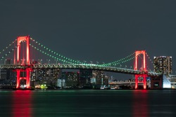 Nightview of Rainbow Bridge, illuminated in red as a sign of 