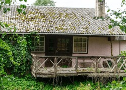 terrace of an old wooden house, wooden house on the river bank, moss covered roof, rural landscape