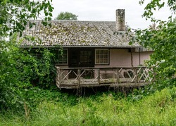 terrace of an old wooden house, wooden house on the river bank, moss covered roof, rural landscape