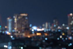 Bokeh abstract background of skyscraper buildings in Bangkok city, Thailand with lights, Blurry photo at night time. Cityscape.