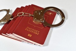 Russian passport and handcuffs on a white background. prohibition of Russian citizens on entry and exit. passport lock
