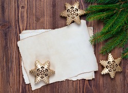Christmas greeting card with old blank paper sheet, fir and snowflakes, wooden background