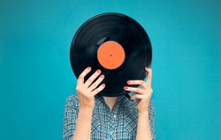 Retro picture of woman with vinyl record on blue background