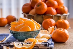 Fresh tangerine and segments on a blue tablecloth.