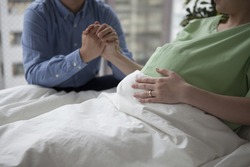 Hands of pregnant woman and her husband