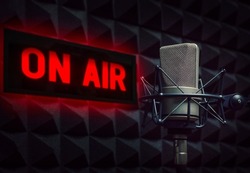 Professional microphone in radio station studio and on air sign