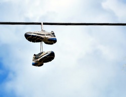 A Pair Of Sneakers Hanging From A Power Line