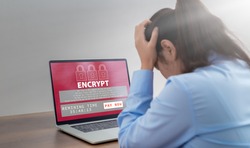 Stressed business woman with computer screen showing personal files encrypted text, Ransomware malware attack. Business computer Hacked. files encrypted.