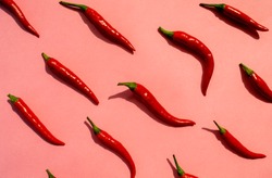 Red chilli peppers pattern on pink background. Top view. Hot pepper flat lay. Chili wallpaper 