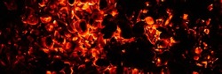 background of burning and glowing hot coals. smoldering embers of fire. flicker of burning coals at night. banner
