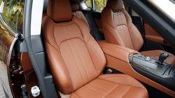 Premium car interior with light brown high-tech comfortable seats and wooden trim                               