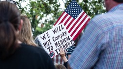 Anti-vaccine mandate protest sign held by child with american flag