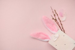 Pink bag, bunny headband and willow branches on a pink background.The concept of Easter, shopping for Easter.