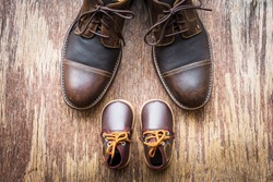 Father and son brown shoes on wooden background, fathers day 