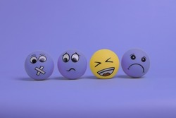 Happy emoticon between a group of sad emoticon characters on Very peri purple background