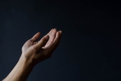 Side view Muslim hands praying isolated on black background with copy space. ramadan kareem concept