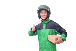 Portrait of Asian online courier driver wearing green jacket and helmet delivering package and box and showing thumb up hand gesture. Isolated image on white background