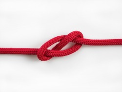 Tied red rope on white background.