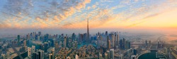Amazing panoramic view of Dubai skyline showing the world's tallest building, Burj Khalifa, during sunset, vibrant skies with clouds in futuristic city downtown; Perfect travel destination panorama
