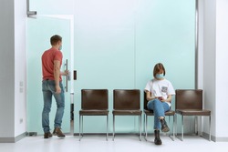 Guy went to a doctor's appointment, and the girl sits in a queue and reads the news about the pandemic on her smartphone