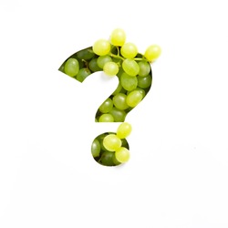 Question punctuation mark made of green grape and cut paper isolated on white. Appetizing typeface of fresh berries