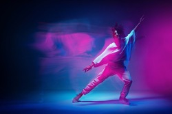 Colourful shot of dancing girl. Female dancer performer show expressive hip hop dance. Colored neon light, long exposure