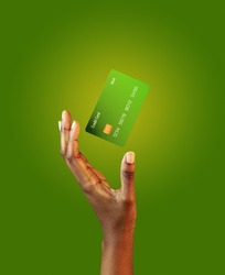 African american female hand and levitating template mockup Bank credit card with online service on green background