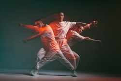 Dancing young girl moving in expressive hip hop dance. Dancer in red studio light. Long exposure. Breakdancing school ad