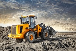 Powerful wheel loader or bulldozer working on a quarry or construction site. Earthworks in construction. Powerful modern equipment for earthworks