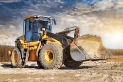 Powerful front wheel loader or bulldozer working on a quarry or construction site. earthworks in construction. Powerful modern equipment for earthworks