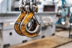 Metal industrial chains with hooks in the workshop of a metallurgical plant. Close-up. Lifting hooks for lifting heavy materials and equipment