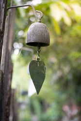 Bronze bell in indian temple in the green crops blur background. Hindu temple brass bell hanging in gold color